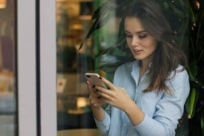 Nachrichten um Ex zurückzubekommen - Junge Frau schaut auf ihr Smartphone